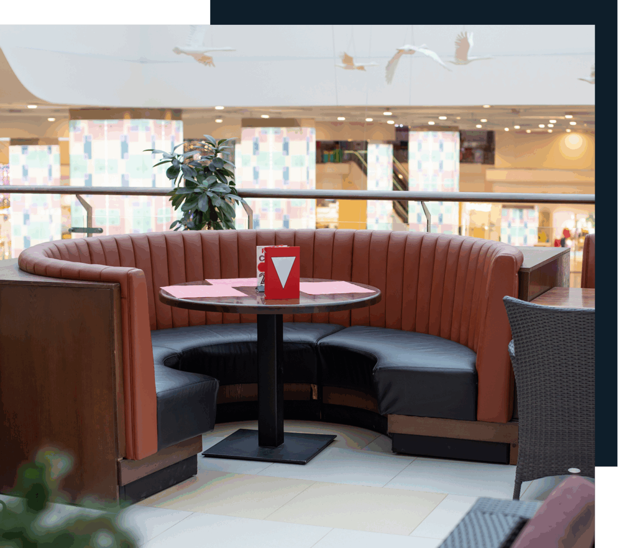 Mall seating area with round booth table.