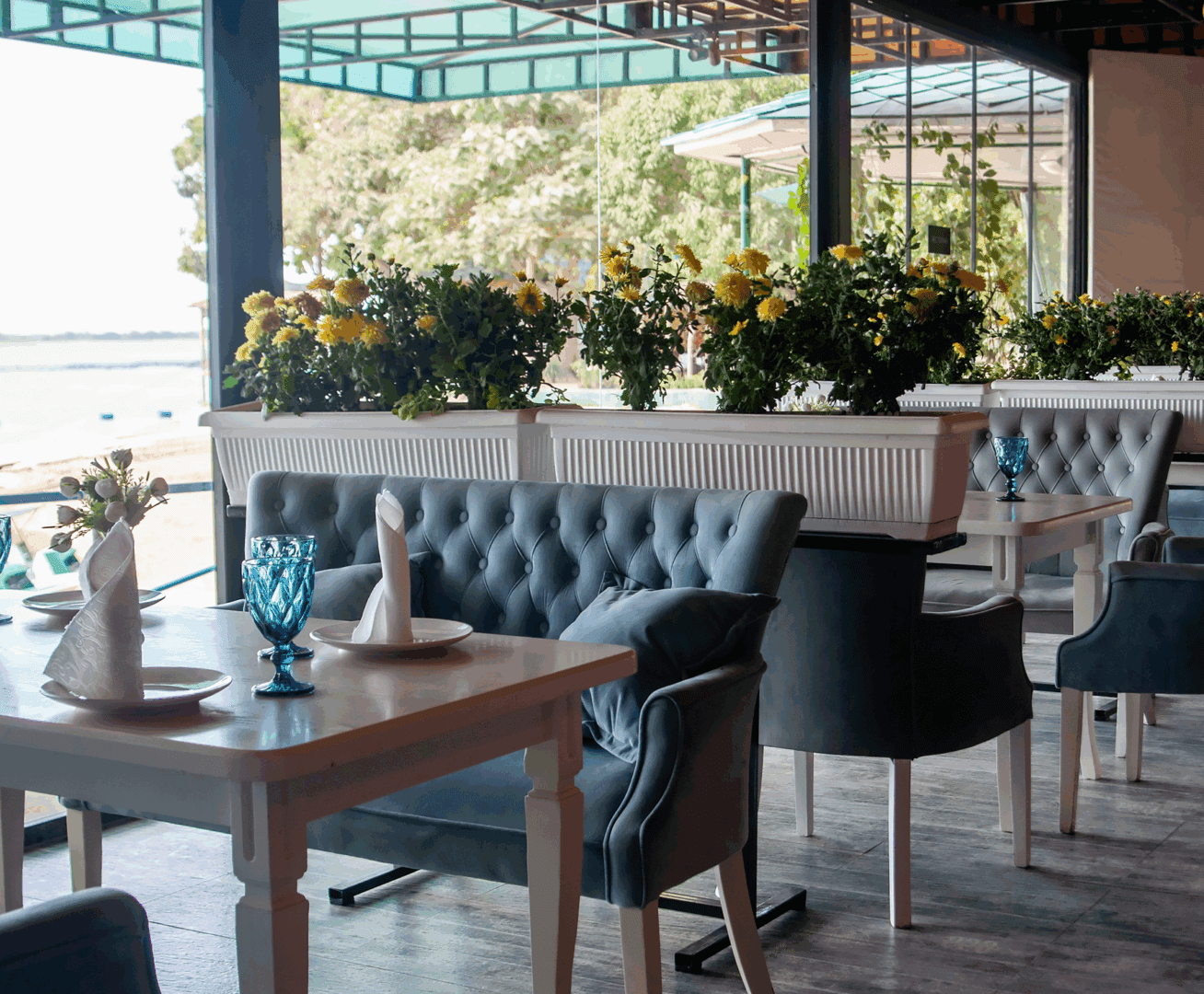 Cozy restaurant with blue chairs and flowers.